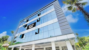 Un moderno edificio de hotel con fachada de vidrio y un cartel que indica que ofrece servicios de empresa.