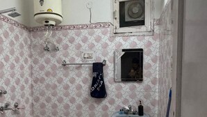A bathroom with patterned walls, a sink, a towel rack, and a shower. - Room-charming B&B Room With Private Faci (Jammu)