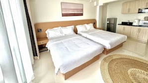 A hotel room with a double bed, a small kitchenette, and a bathroom. - Royal Oceancrest Panglao 1 (Dauis)