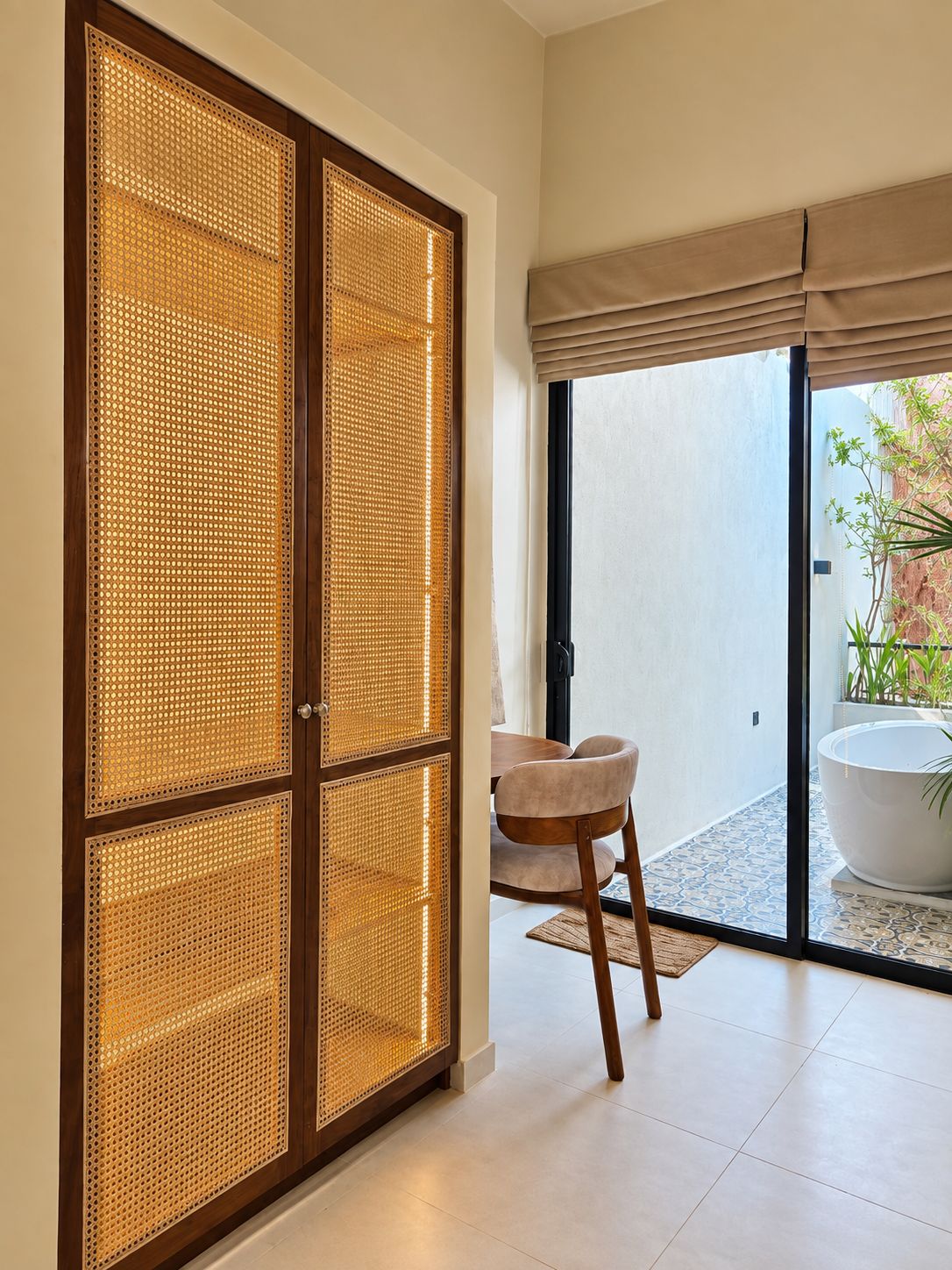 Una habitación con puerta corredera, una silla, un tazón blanco grande y vistas a un jardín.