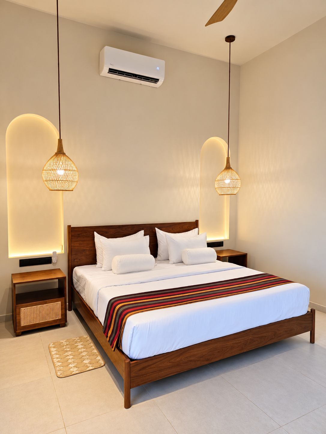 Un dormitorio moderno con una cama de madera, dos mesitas de noche, un tapiz tejido e iluminación colgante.