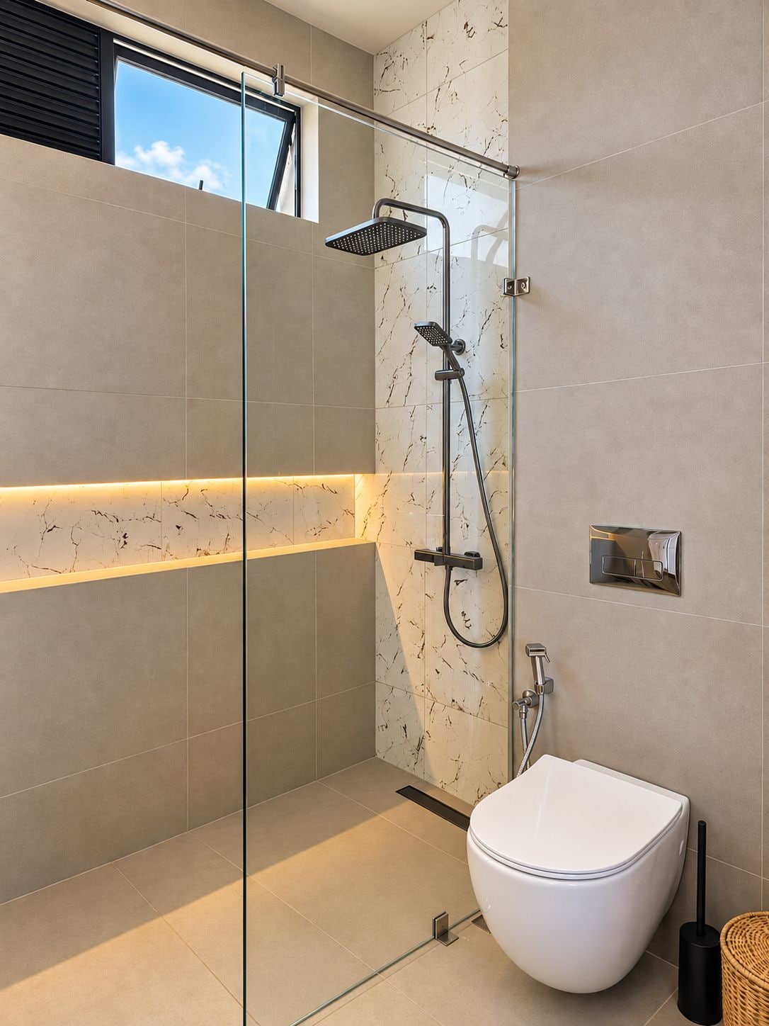 A modern bathroom with a glass-enclosed shower, a white toilet, and a marble-tiled wall.