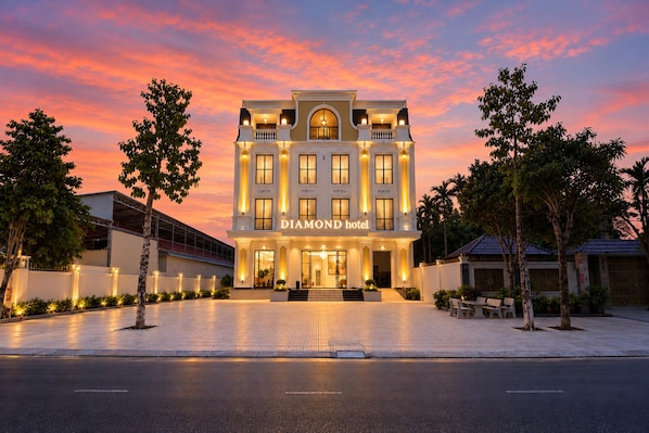 A multi-story hotel with a grand entrance, named 'DIAMOND hotel,' featuring a symmetrical facade with multiple windows and a central entrance.
