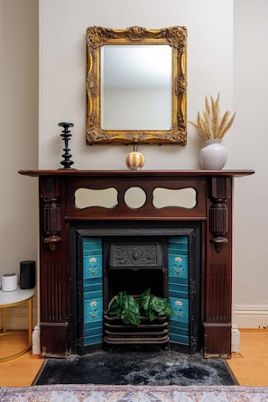 A fireplace with a decorative mantel, a mirror above it, and a vase with dried plants on the mantel. - Charming 2BD Near ICC, Casino and Darling Harbour (Pyrmont)