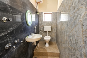 A bathroom with a sink, toilet, and a mirror on the wall. - Rch Home Stay (Rameswaram)
