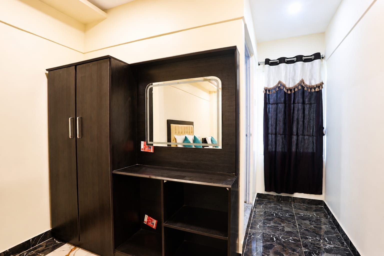 A room with a wardrobe, a mirror, and a shower curtain.