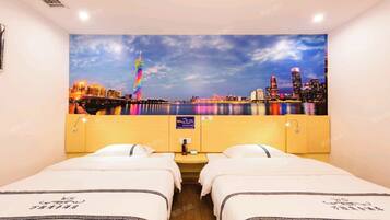 Habitación de hotel con dos camas, un mural de paisaje urbano en la pared y vista a un río.