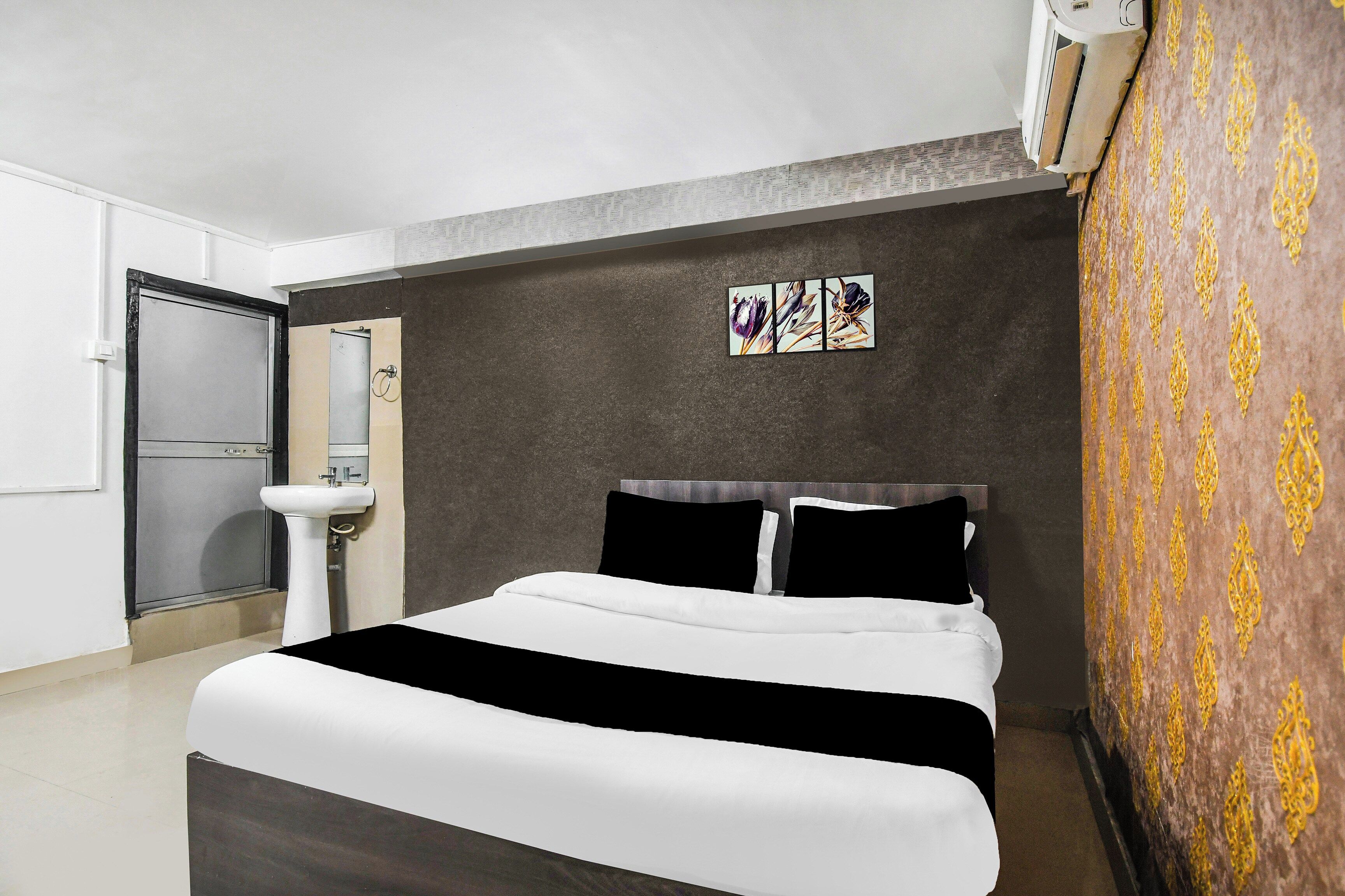 Habitación de hotel con una cama, un lavamanos y aire acondicionado instalado en la pared.