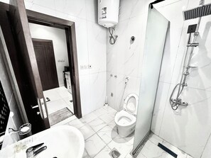Une salle de bain moderne équipée de toilettes, d’un bidet et d’une douche.
