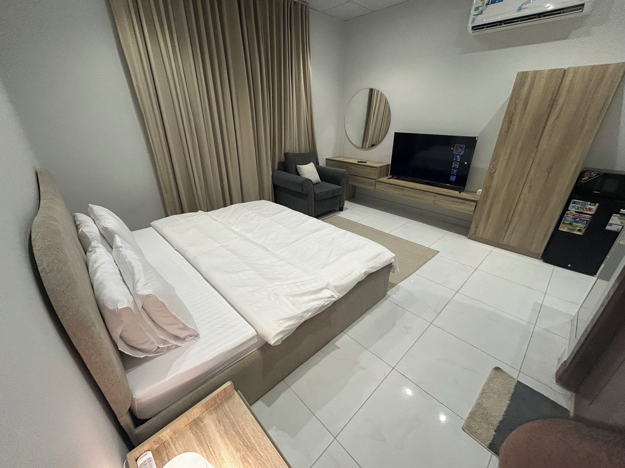 A hotel room with a bed, a TV, a desk, and a wardrobe.