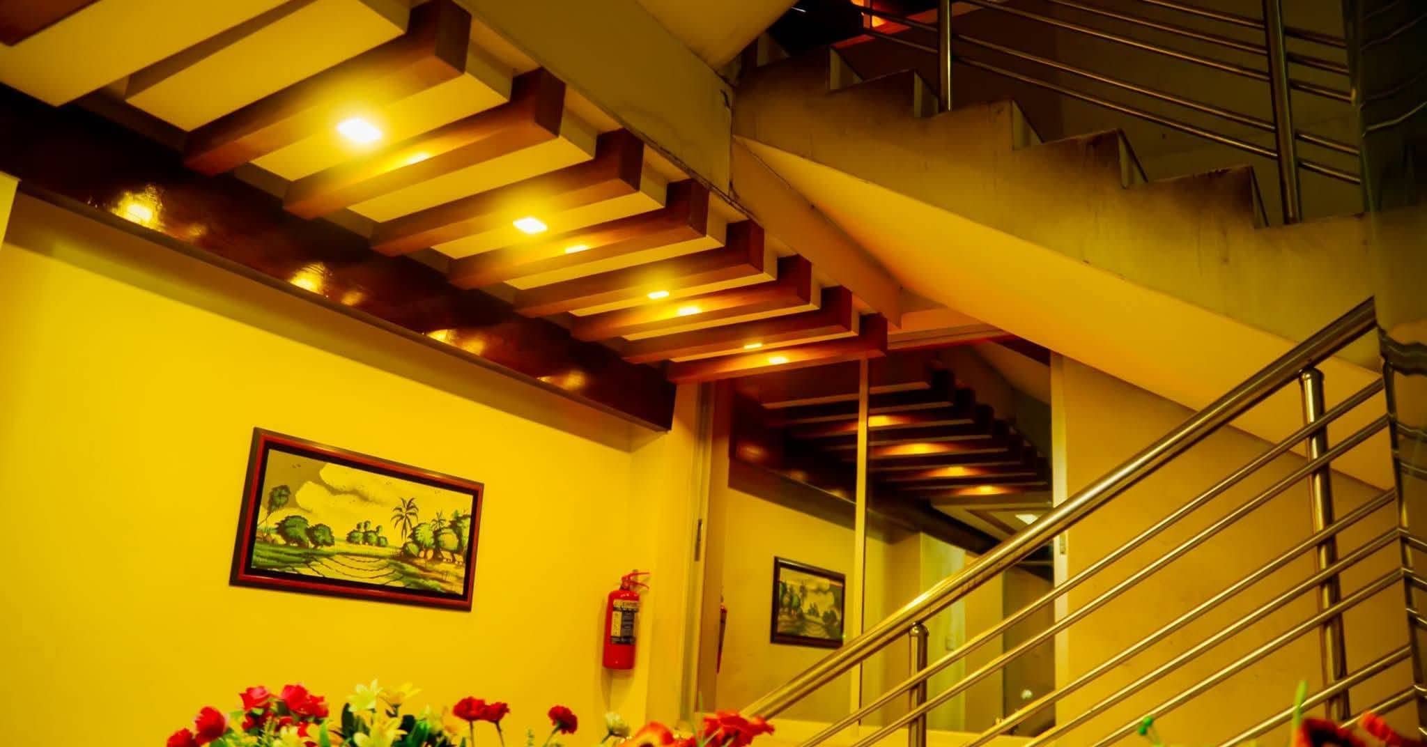 A staircase with a metal railing and a ceiling with recessed lighting.