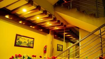 A staircase with a metal railing and a ceiling with recessed lighting.