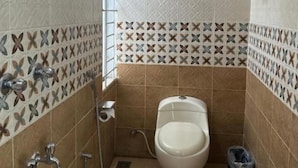 Pieni kylpyhuone, jossa on wc, suihku ja käsienkuivaaja.