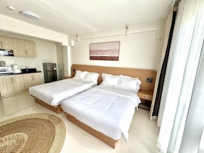 A hotel room with two beds, a kitchenette, and a view of the beach. - Royal Oceancrest Panglao 1 (Dauis)