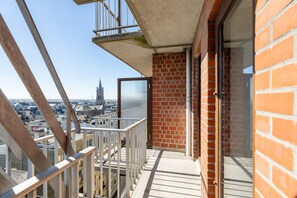A balcony with a view of a cityscape, including a church tower. - Apartment in Blankenberge Near the Pier (Blankenberge)