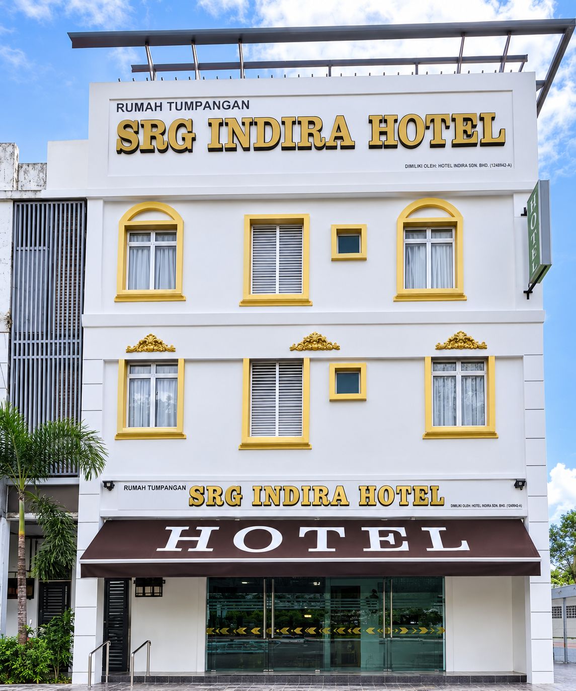 A multi-story hotel with a prominent sign reading 'SRG INDIRA HOTEL' and a brown awning below.