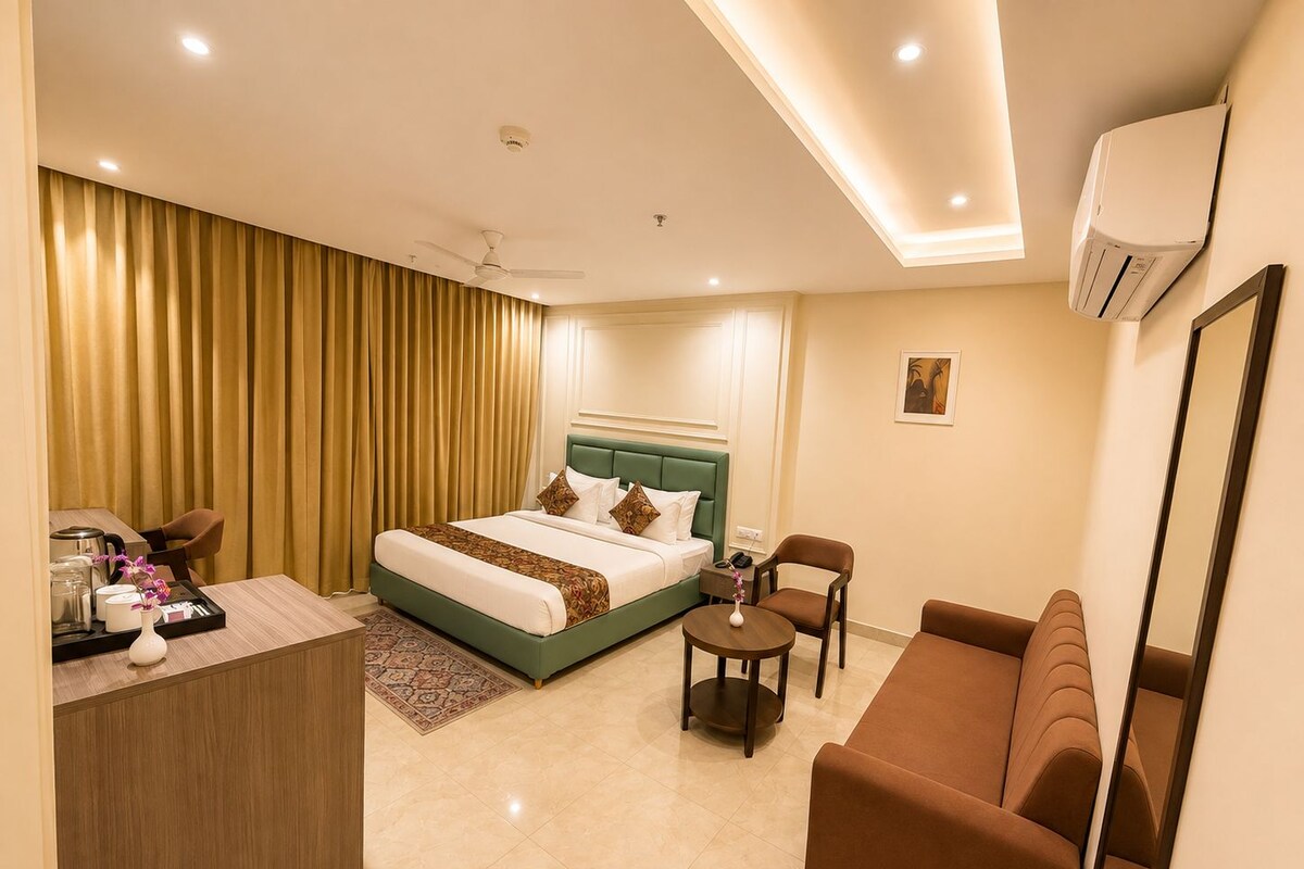 Una habitación de hotel moderna con cama, sofá, escritorio y zona de comedor.