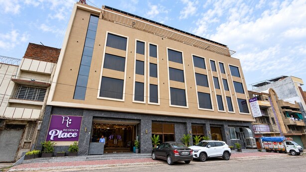 A multi-story building with a ground-level entrance, a sign for 'Regenta Place,' and parked cars in front. - Regenta Place Kota (Kota)