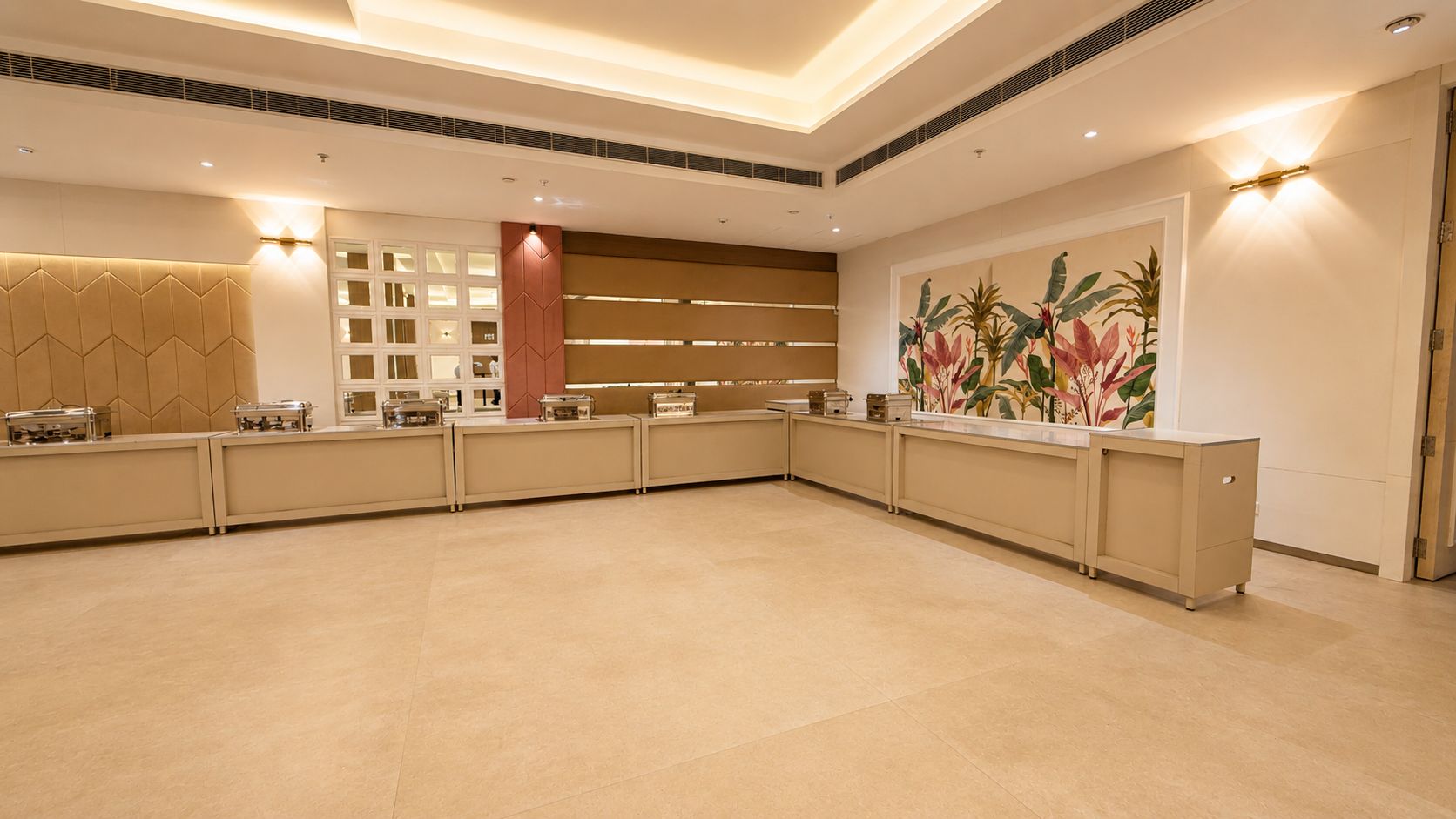 Amplia zona de recepción bien iluminada, con una larga barra de atención, un muro decorativo con un mural tropical y un diseño de techo moderno.