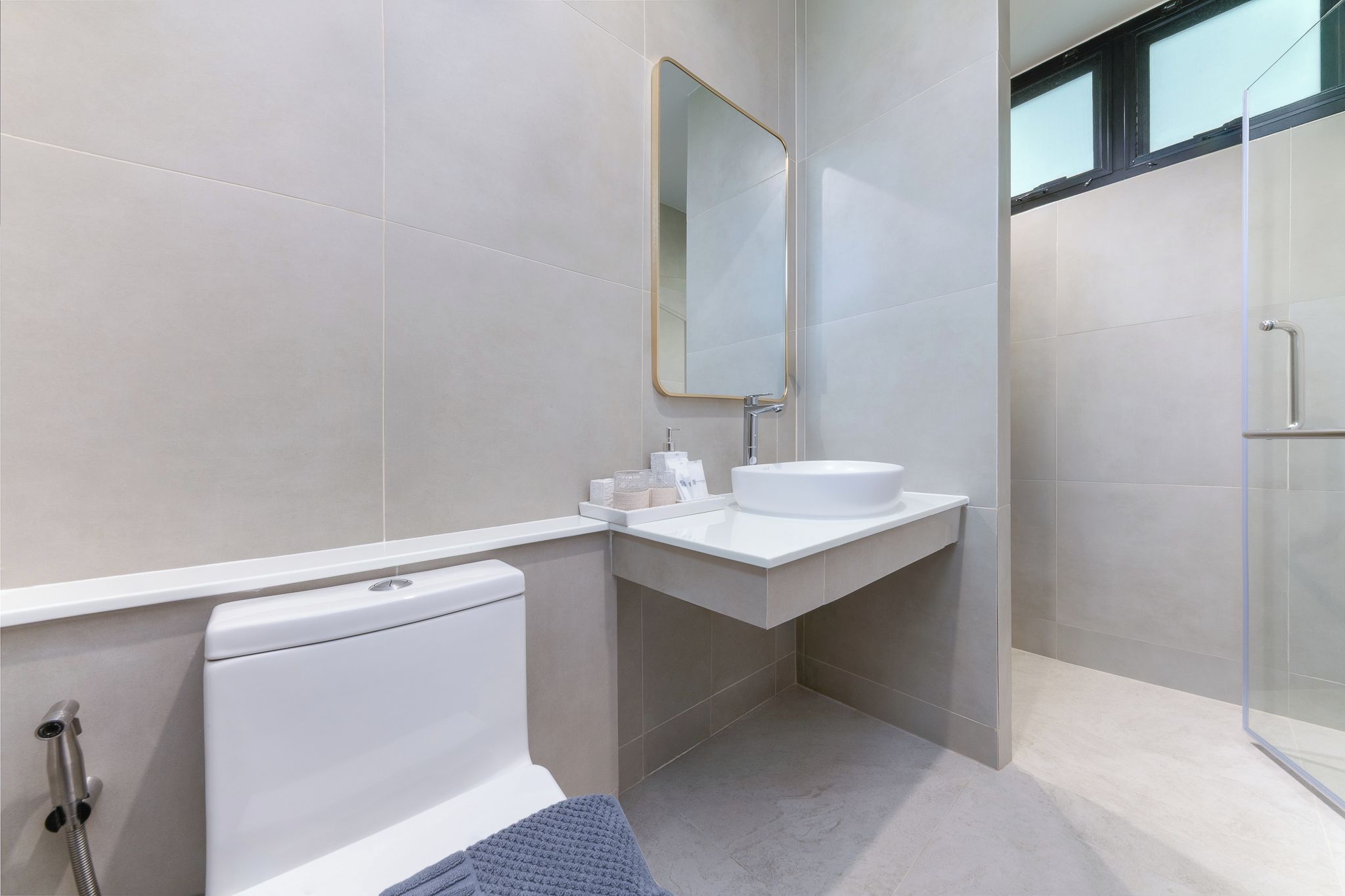 A modern bathroom with a toilet, sink, and shower.