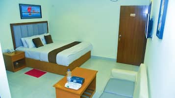 A hotel room with a bed, bedside table, chair, and a door marked with the number 202.