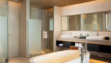 A modern bathroom with a freestanding bathtub, glass shower enclosure, and a large mirror above the vanity.