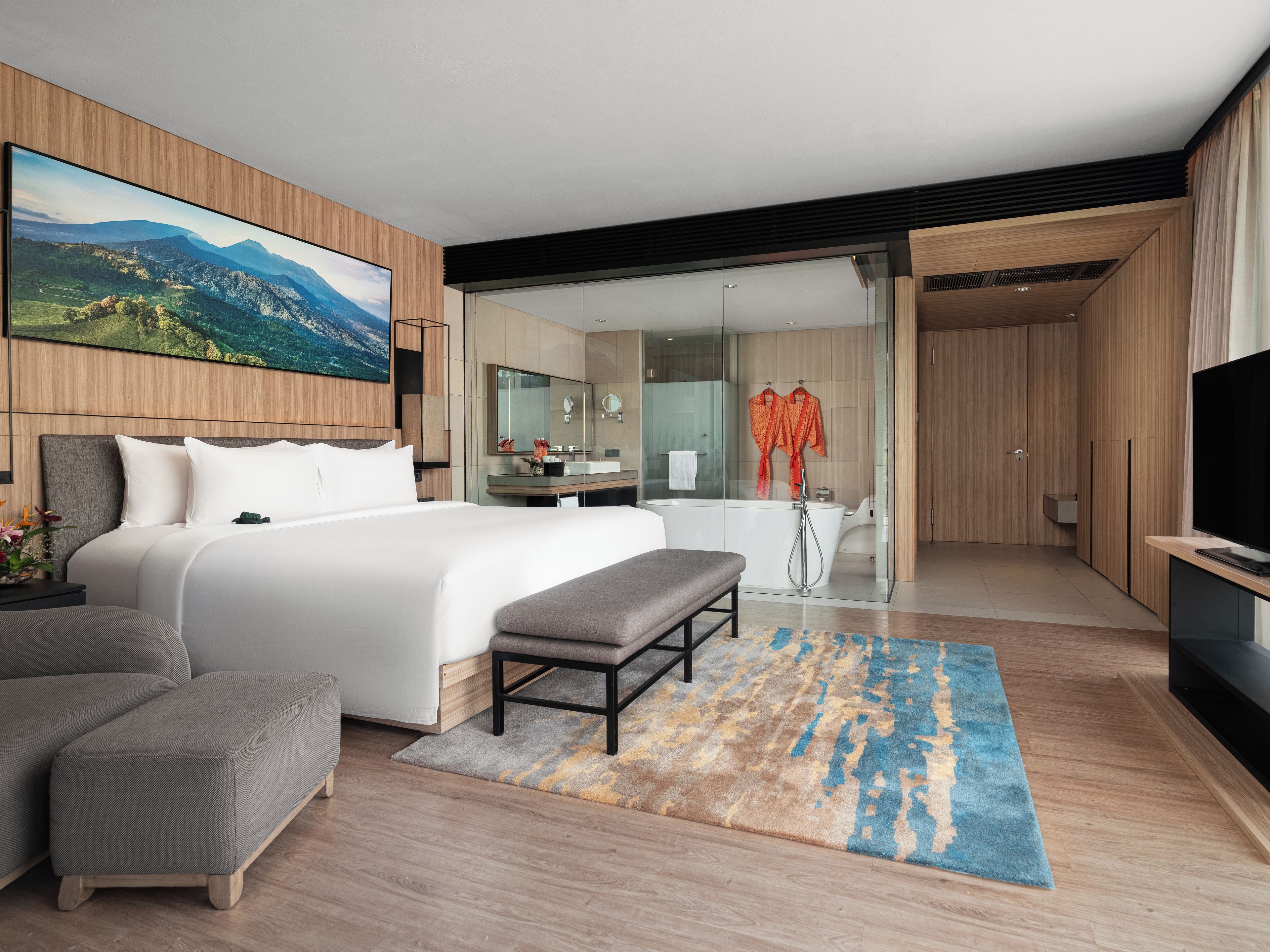 Een moderne hotelkamer met een groot bed, een zithoek, een badkamer met douche en een televisie.