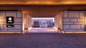 A spacious lobby with a modern design, featuring a wooden ceiling and a brick floor.