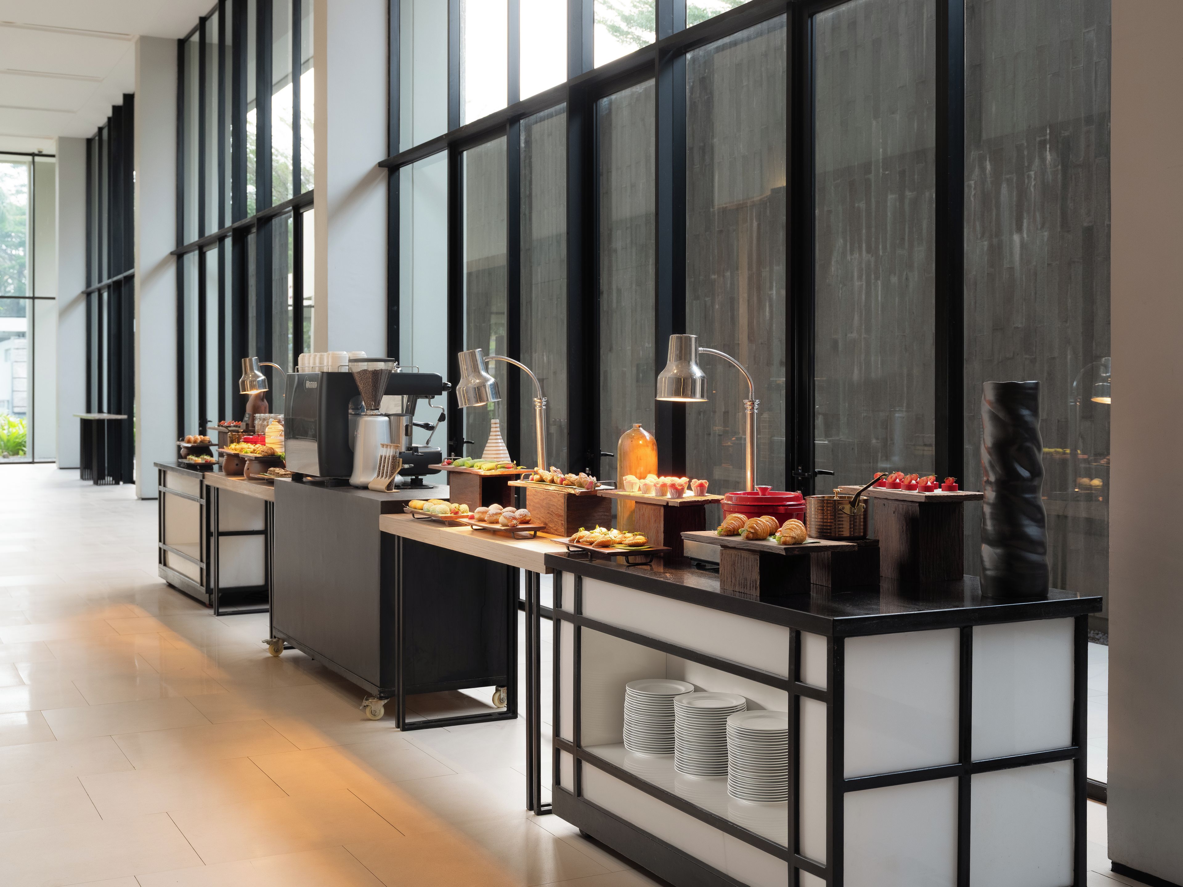 A buffet setup with various food items, a coffee machine, and a beverage dispenser.