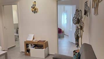 Un saló modern amb un sofà, una taula de centre i una planta decorativa.