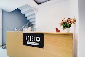 Un comptoir de réception d’hôtel avec un panneau indiquant qu’il est géré par l’entreprise.