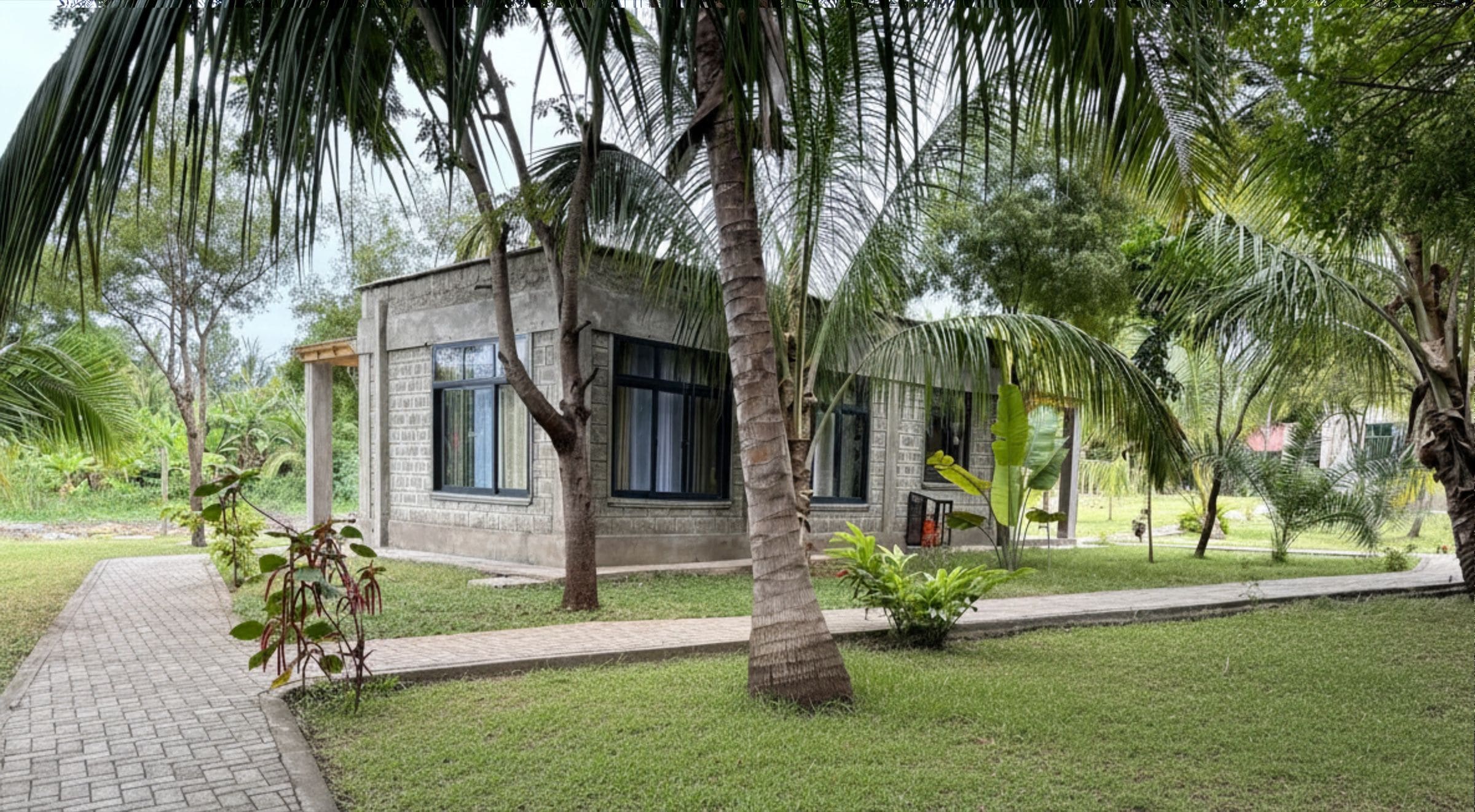 A small, single-story building with a brick exterior, surrounded by a well-maintained lawn and palm trees.