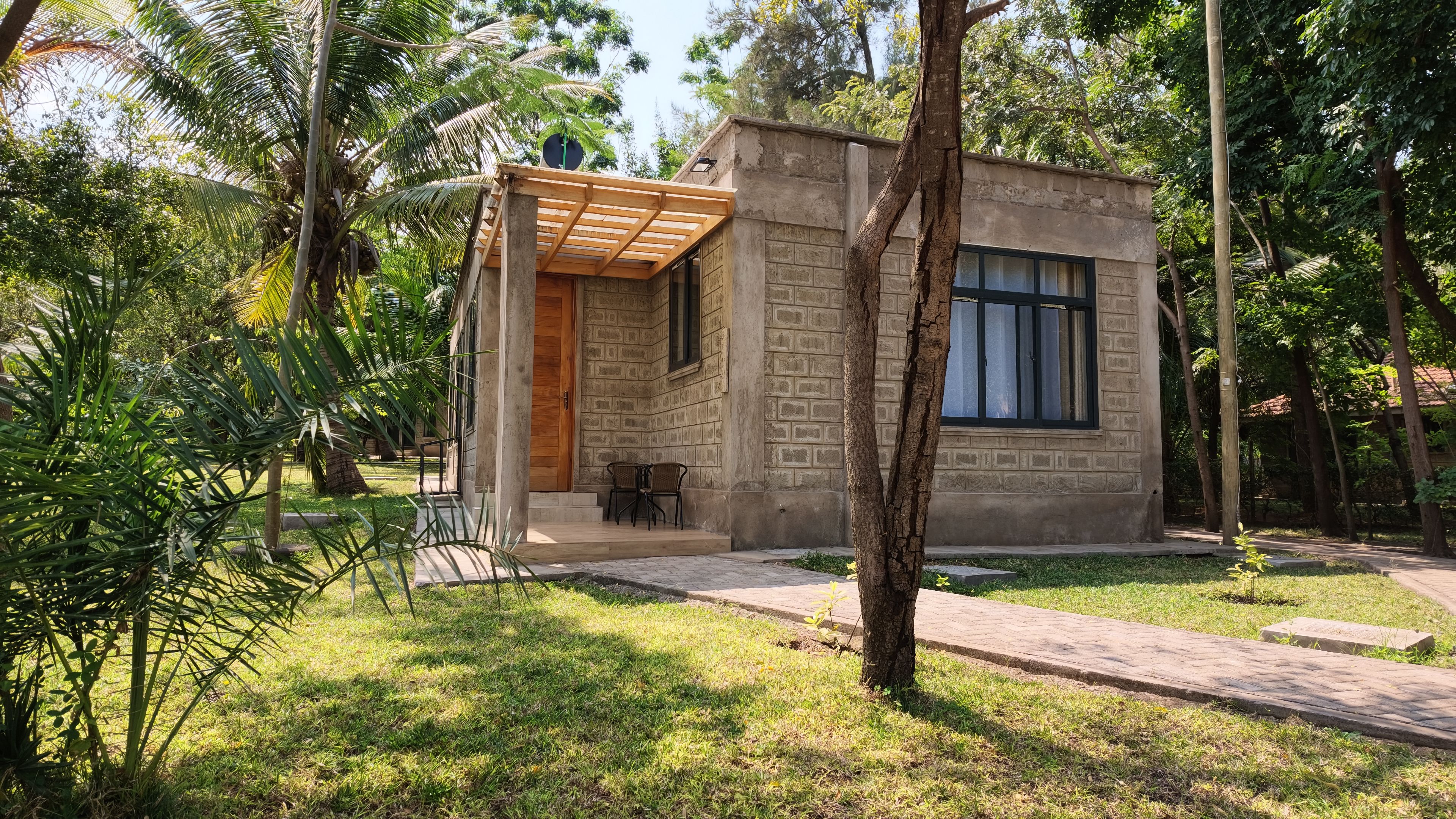 A small, single-story building with a wooden porch and a window.