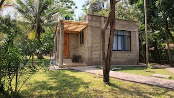 A small, single-story building with a wooden porch and a window.