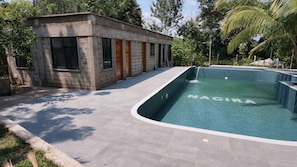A swimming pool with a curved edge and the word 'NACIRA' on the water.
