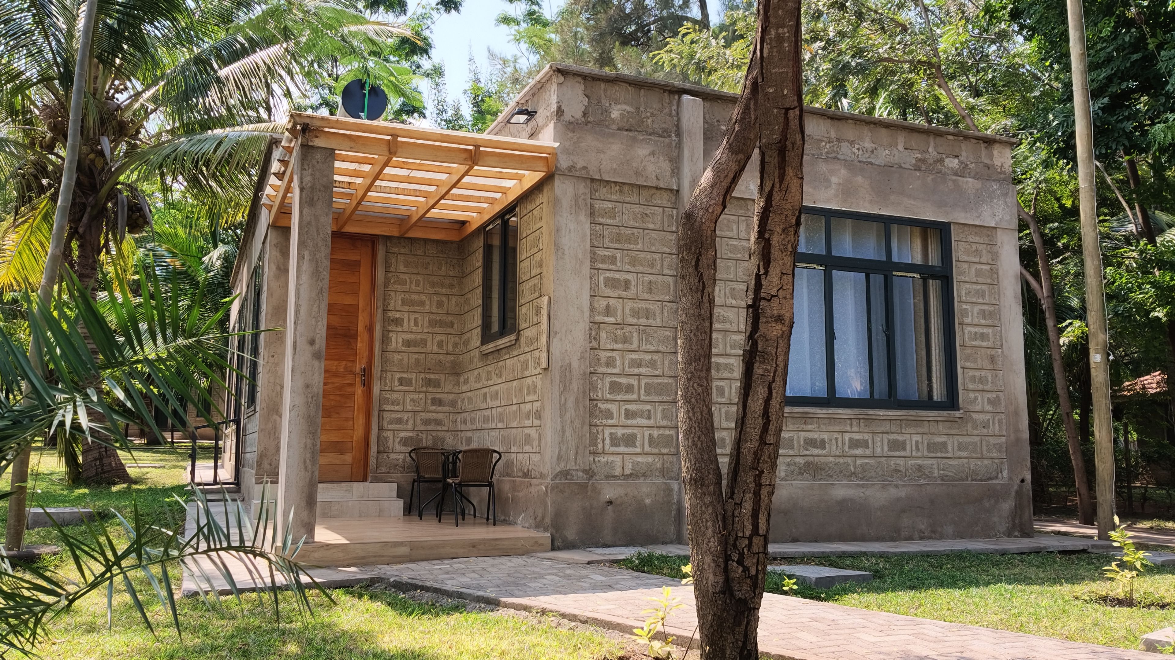 A small, single-story building with a brick exterior, a wooden door, and a window.