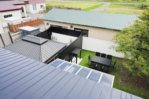 A residential building with multiple roofs, including a flat roof and a sloped roof with skylights.