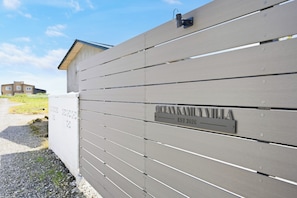 A gated entrance with a metal sign indicating 'OCEANKAVIVILLA EST 2026'.