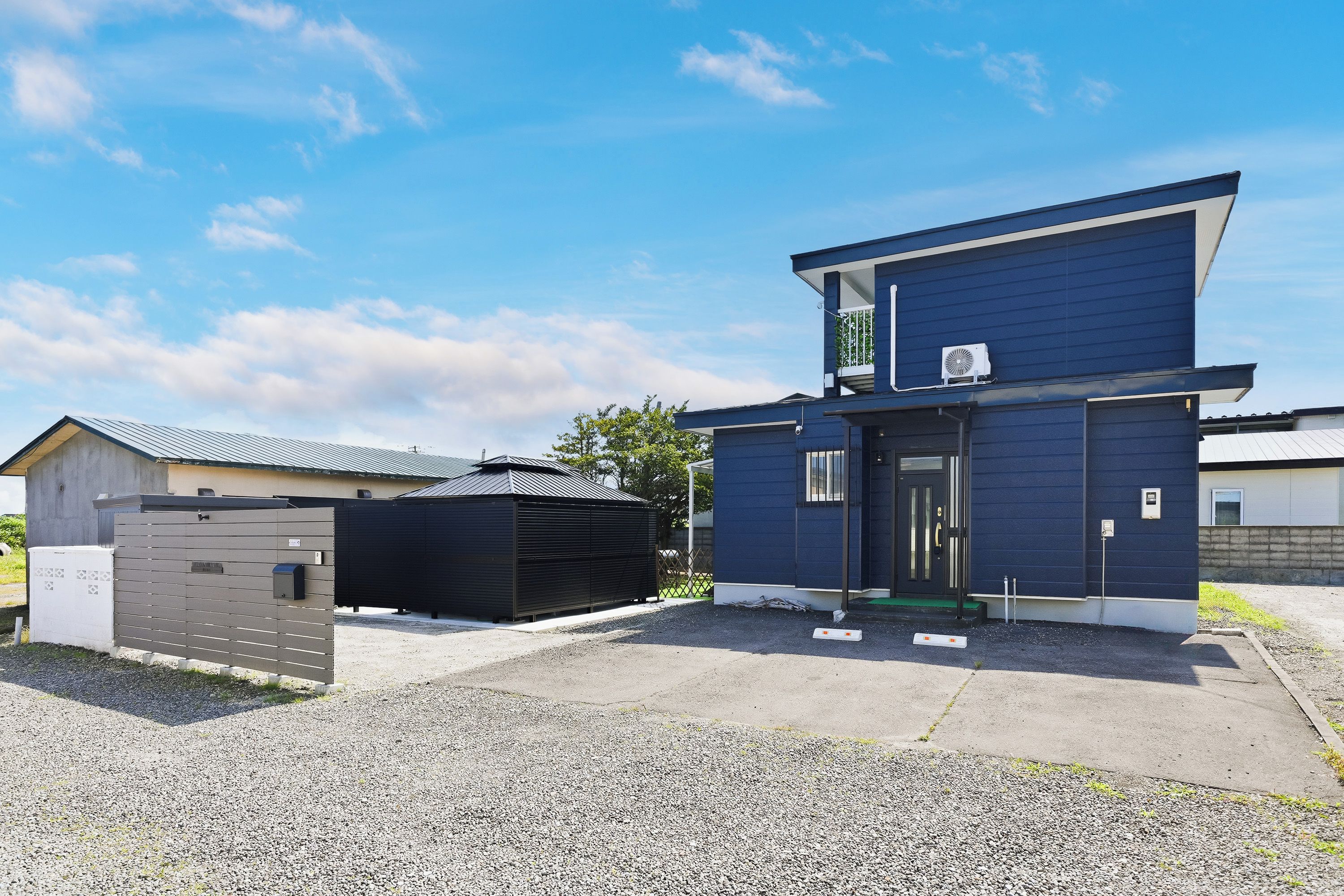 A modern two-story building with a flat roof, a covered entrance, and a small porch.