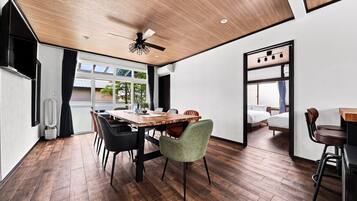 Un intérieur moderne comprenant un coin repas, un ventilateur de plafond et une vue sur l’extérieur.