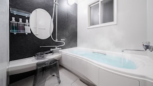 Een moderne badkamer met een badkuip, douche, wastafel met spiegel en een raam.