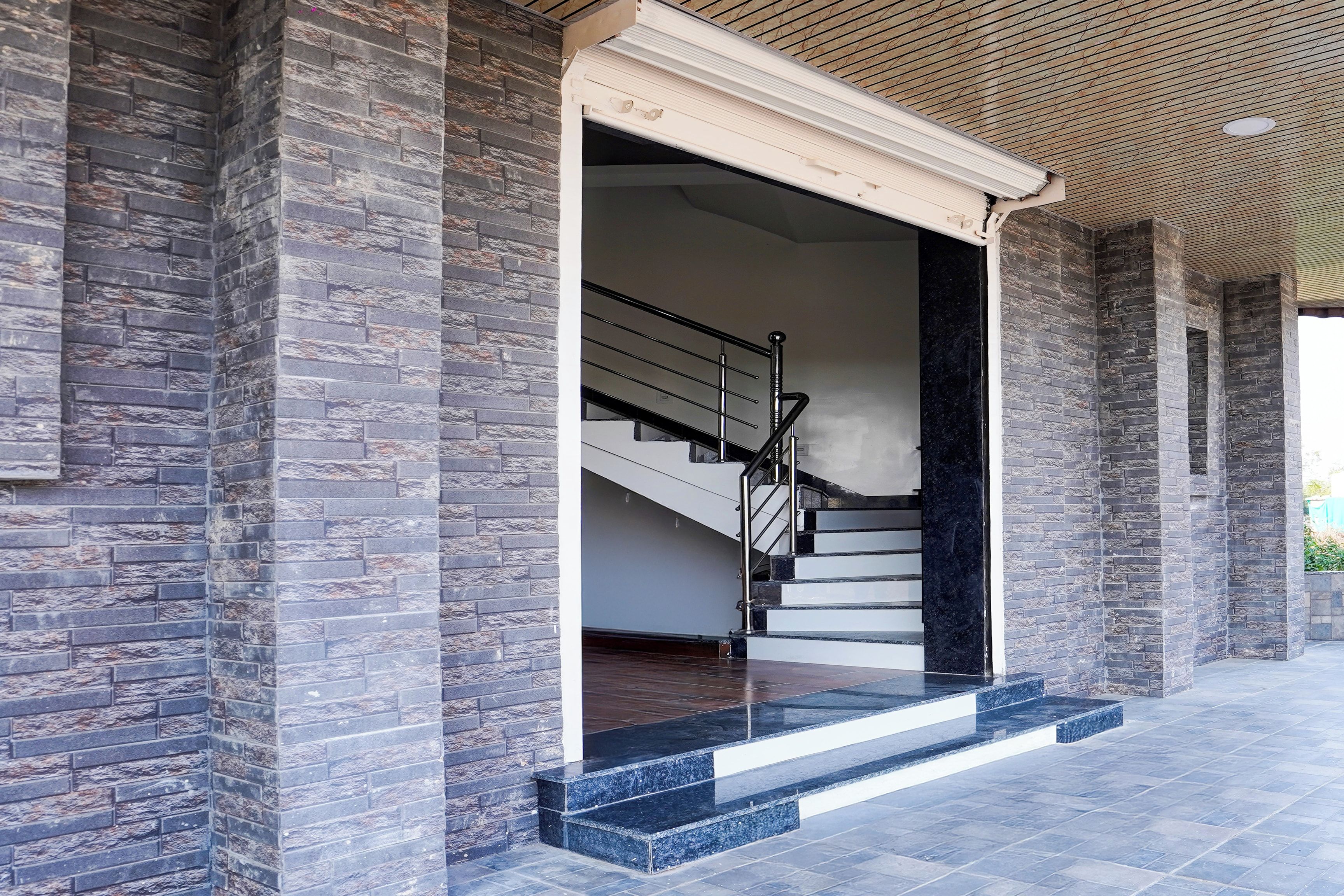 Una entrada de edificio con una escalera que conduce a un piso superior, rodeada de muros de piedra.