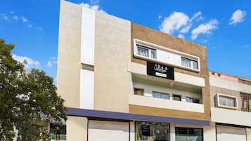 Un edificio moderno con fachada plana, varias ventanas y un letrero que indica que es un establecimiento de recogida con servicios de empresa.