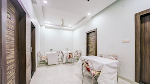 A conference room with a long table, chairs, and a ceiling fan. - Collection O Ujjain City Centre (Ujjain)