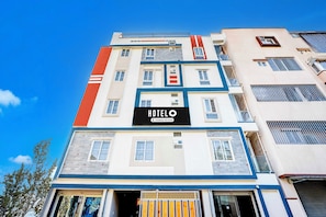 Un edificio de hotel de varios pisos con un llamativo letrero que dice 'HOTEL' en la fachada.