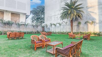 Un espacio de estar al aire libre con muebles de mimbre y una palmera.