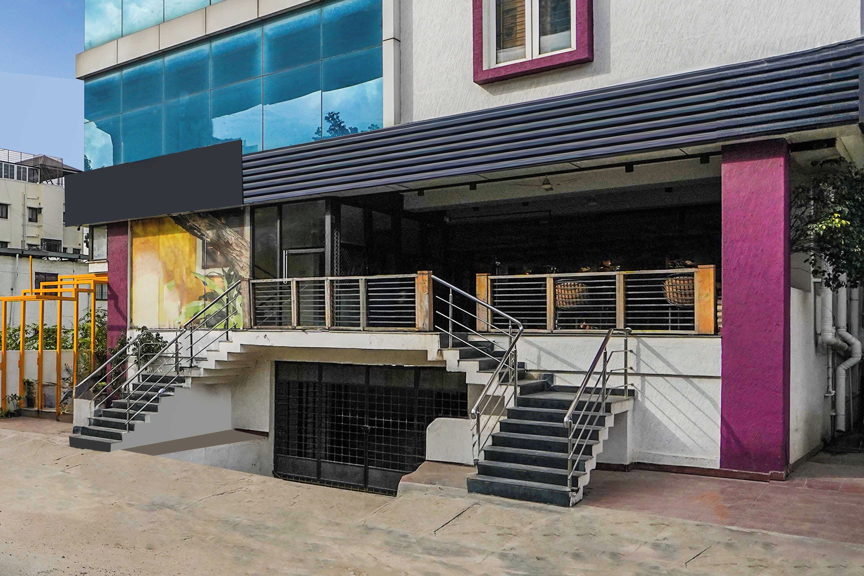 A building with a modern design, featuring a staircase leading to a covered area with a railing.