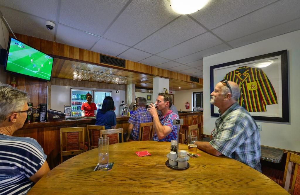 A bar area with wooden furniture, a television screen, and a framed jersey on the wall.