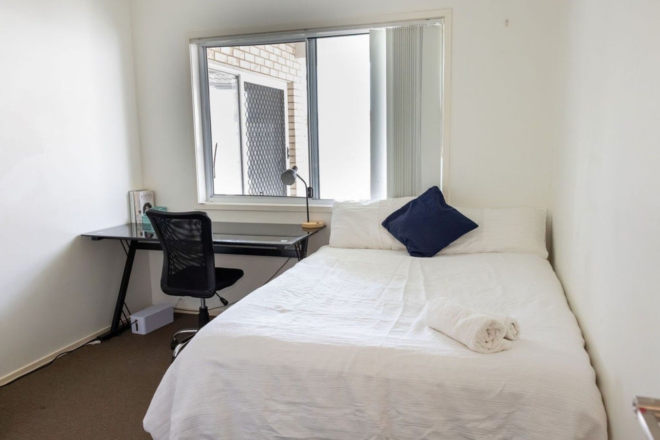 Une chambre avec un lit, un bureau et une chaise.