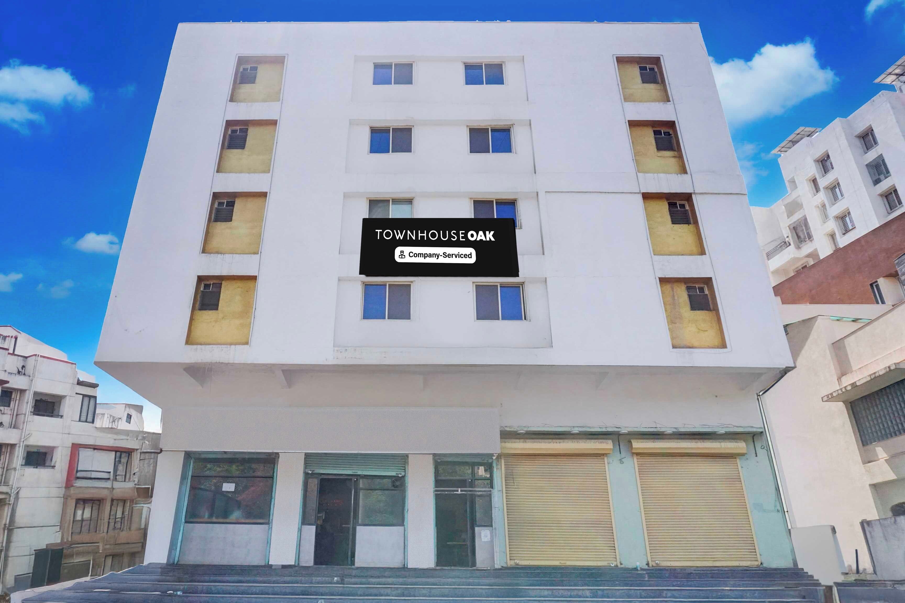 A multi-story building with a sign that reads 'TOWNHOUSE OAK Company Serviced'.